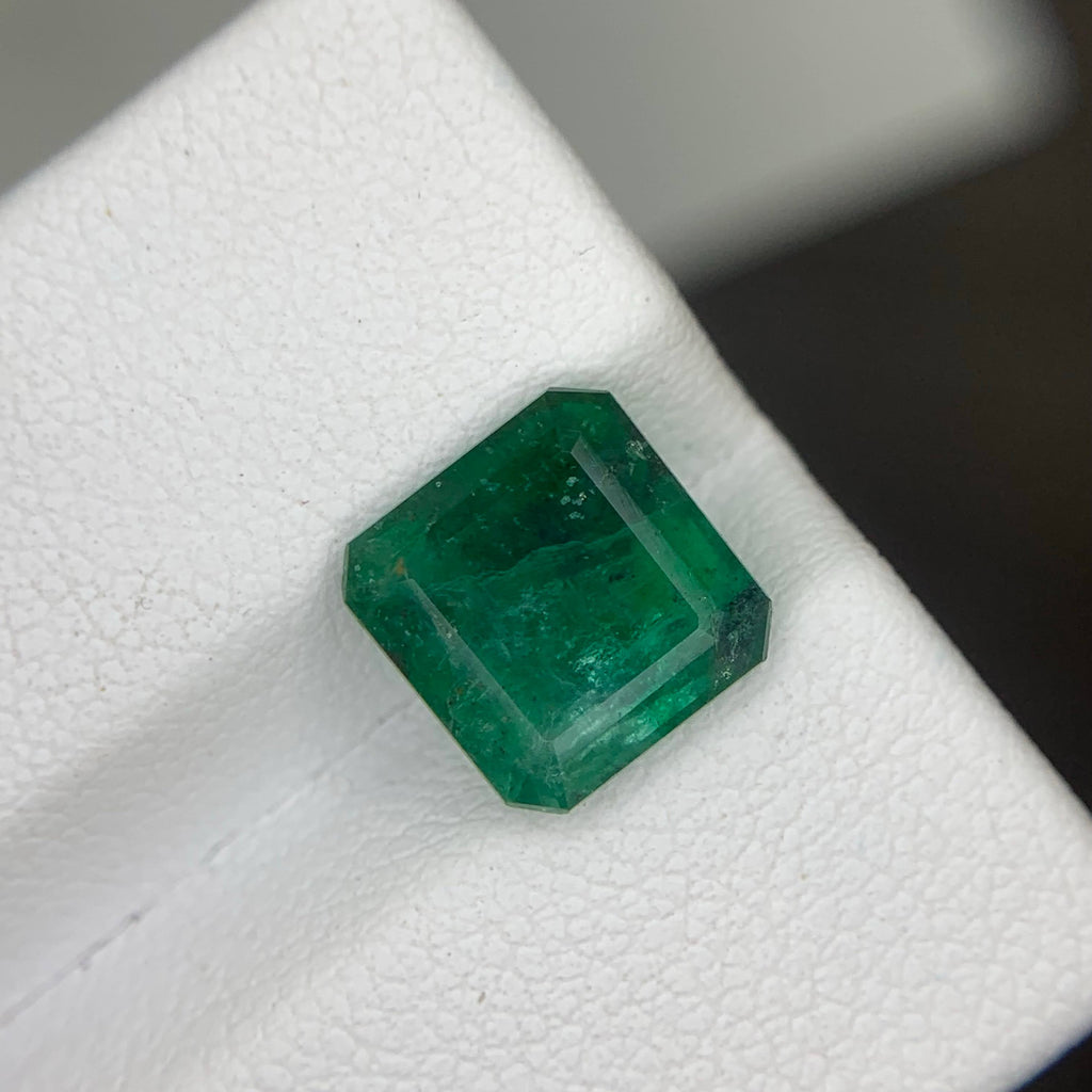 Faceted green gemstone on a white background