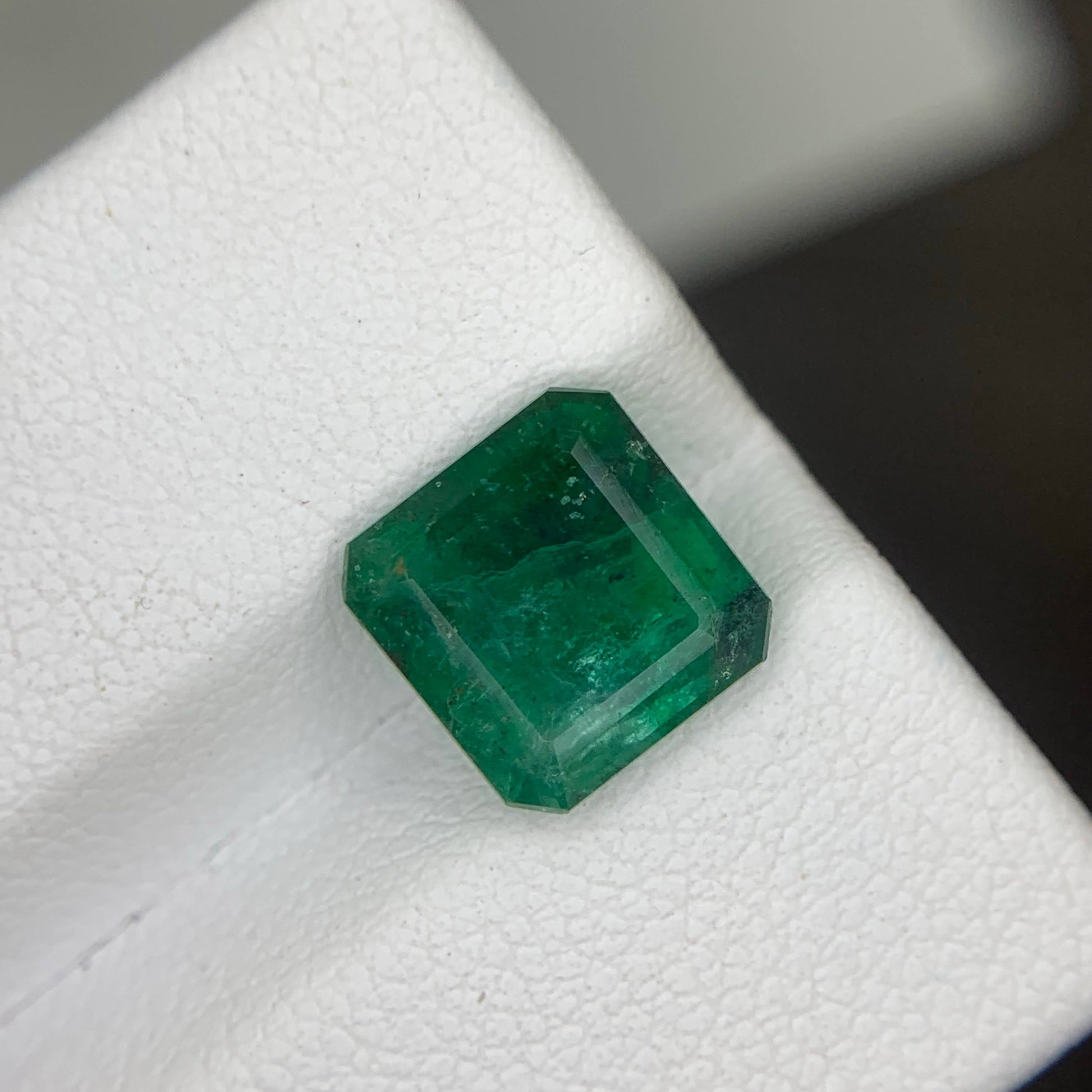 Faceted green gemstone on a white background