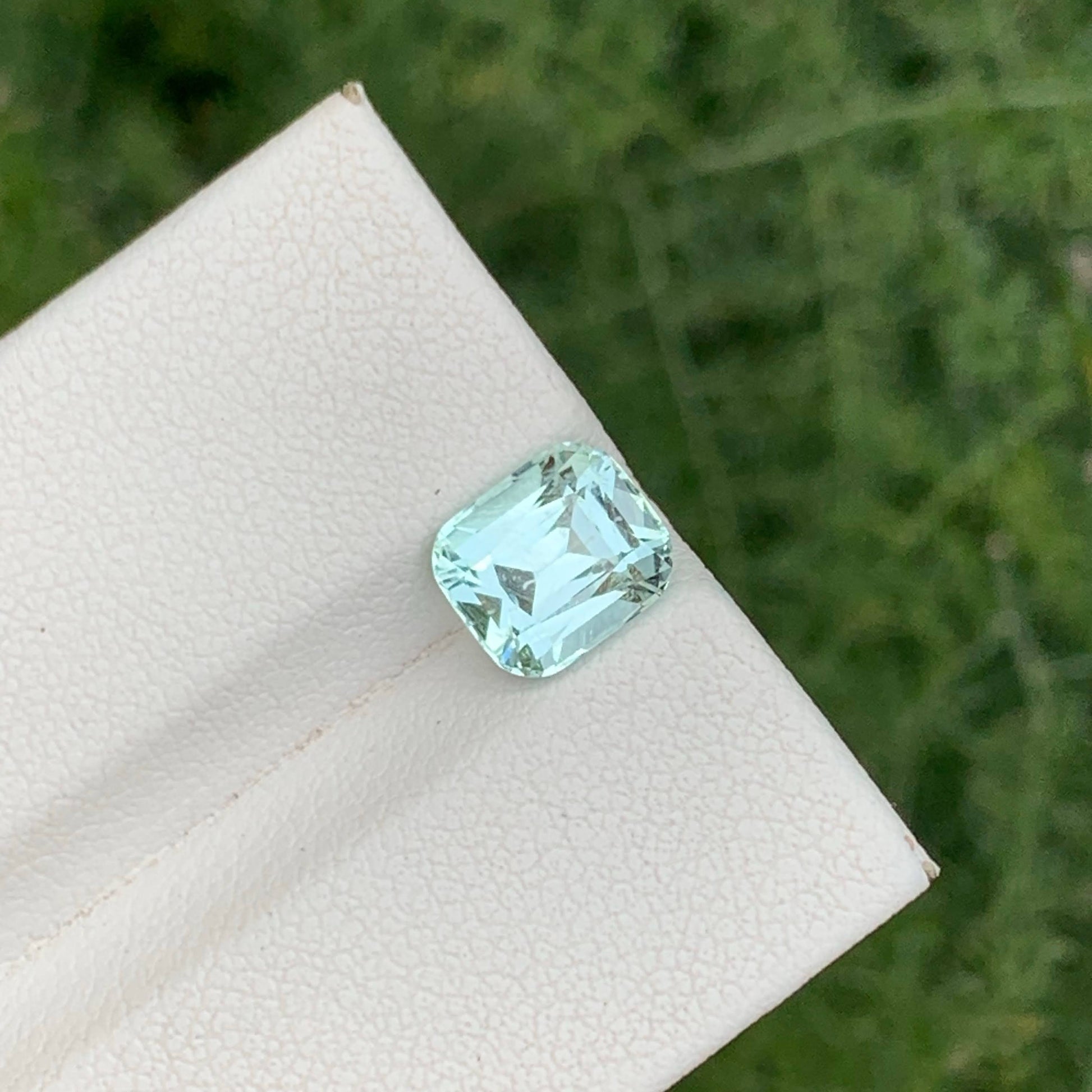 Green gemstone on a white stone with a blurred green background