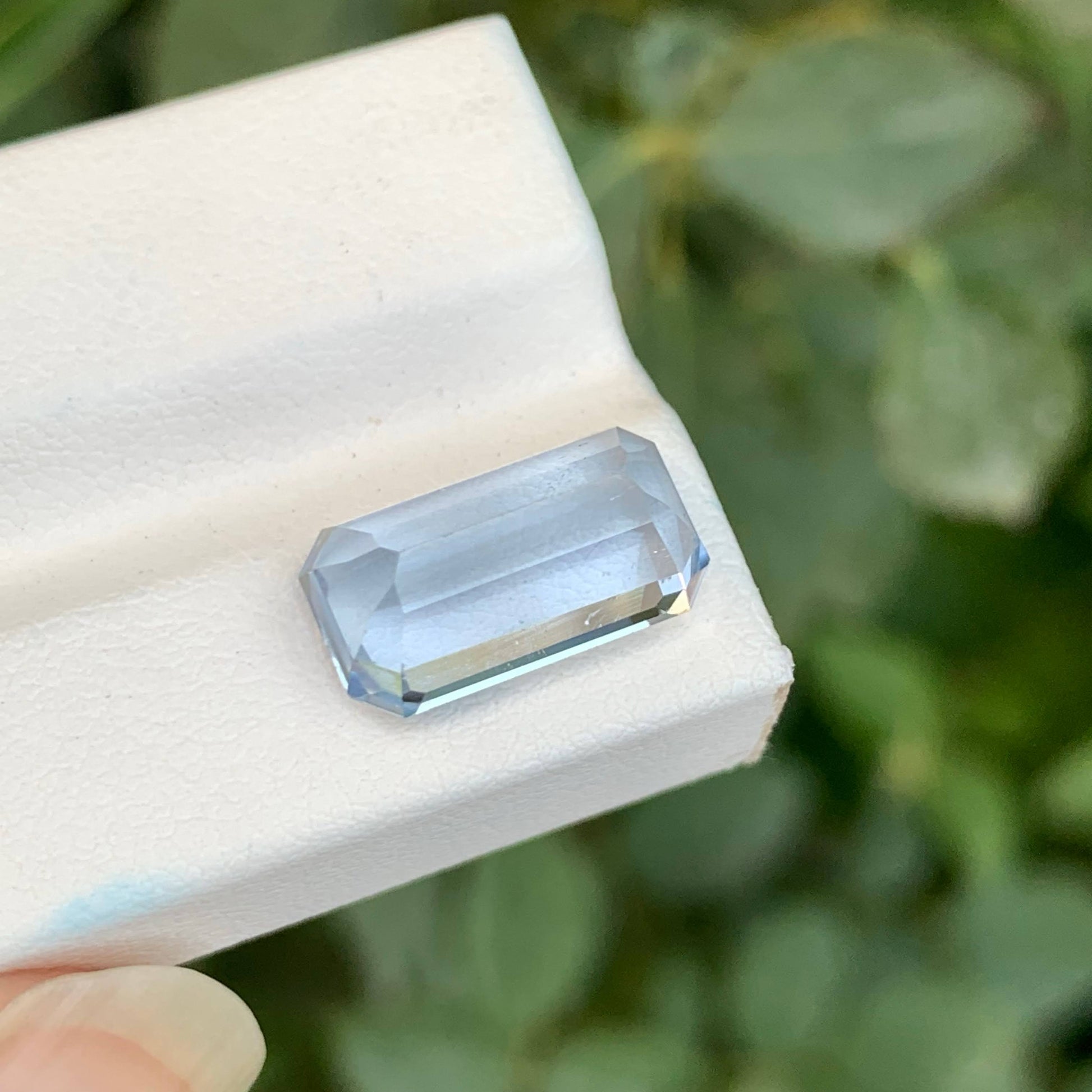 Clear gemstone on a white stand with a blurred green background