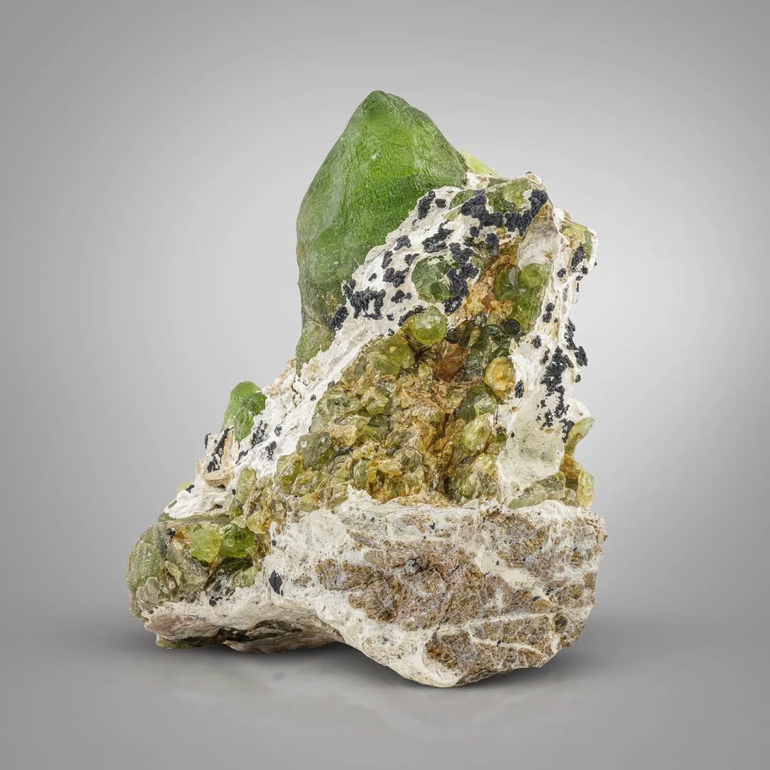 Pointed Peridot Crystal Perched on Matrix with Magnetite from Pakistan