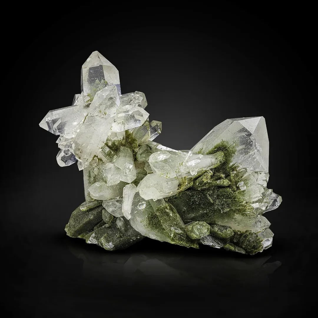 Crystal formation with green and clear minerals on a black background